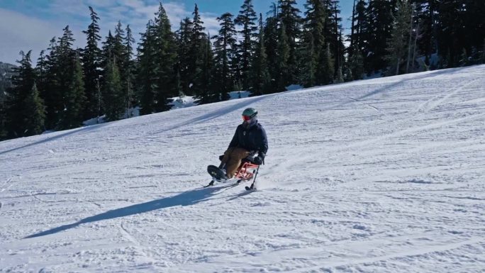 适应性运动员使用手持支腿坐式滑雪
