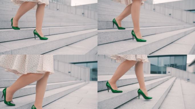 一个不知名的女人穿着裙子和绿色的细高跟鞋走下城市的楼梯