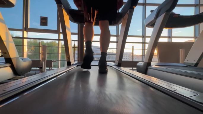 波兰罗兹2023年5月20日一名穿着运动鞋的男子在健身房的跑步机上进行有氧运动训练