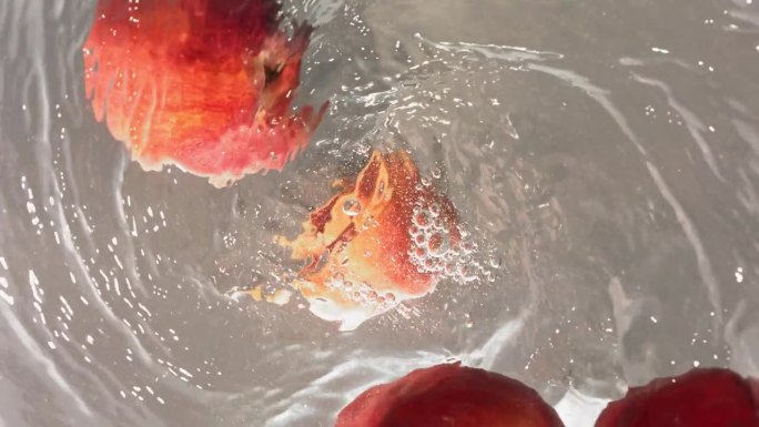 新鲜桃子落入水漩涡的超级慢动作镜头
