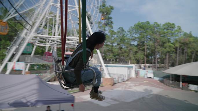 短发女生在游乐场玩旋转飞椅空中飞椅