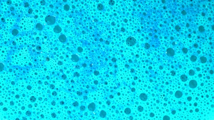 皂液微观结构。带有气泡的蓝色泡沫肥皂，旋转抽象背景，微距镜头，4k。