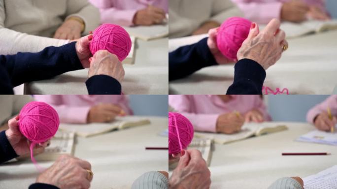 近距离拍摄一位老妇人的手，她在疗养院里缠毛线。高品质4k画面