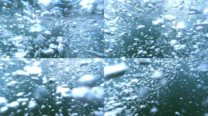 在阳光的照射下，通过气泡从海底上升到水面的慢动作镜头探索水下世界。非常适合作为抽象背景。
