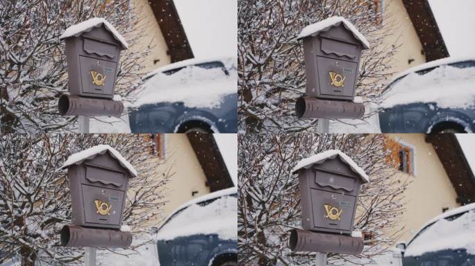 雪落在房子车道上的信箱上