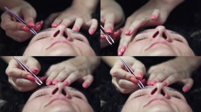 美容院美容师用镊子为一位女士拔眉塑形的特写