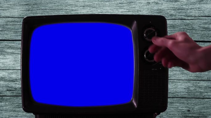 男人用手打开有蓝屏的旧电视。特写镜头。4 k决议。