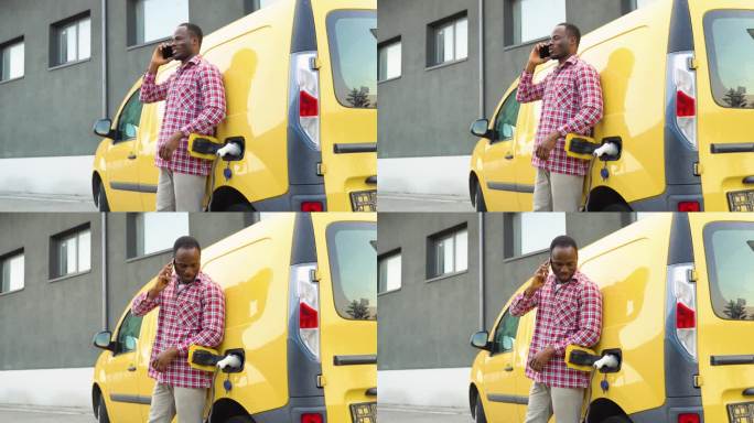 黑人男子在电动汽车充电站给货车充电时打电话