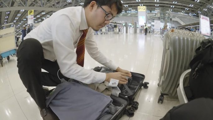 一名男子打开行李寻找遗失物品的时间间隔，如护照、身份证、机票等