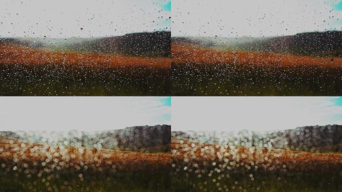 特写窗户上的雨滴，可以看到农村的麦田