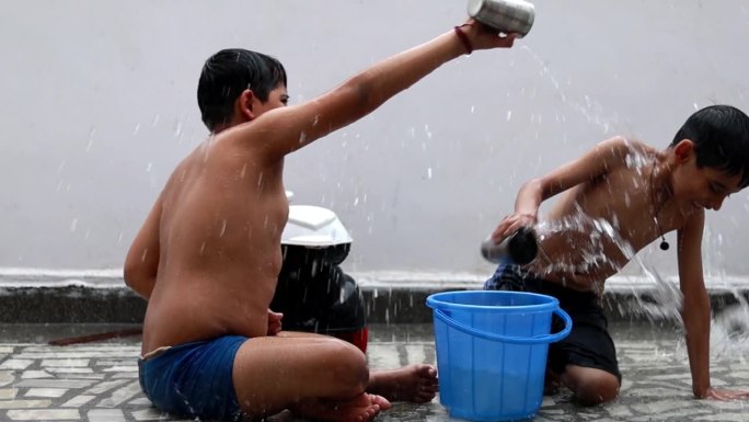 在雨季，嬉戏的孩子们在雨中洗澡