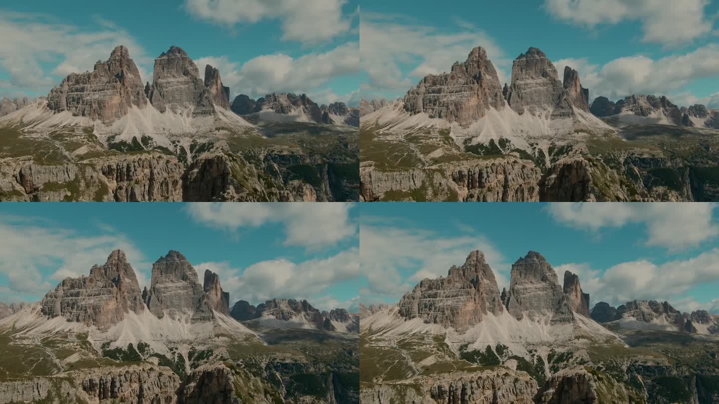 跟踪无人机拍摄，以高大陡峭的岩石山脉和部分多云的天空为背景，度假和度假在阿尔卑斯山雄伟的景观，电影色