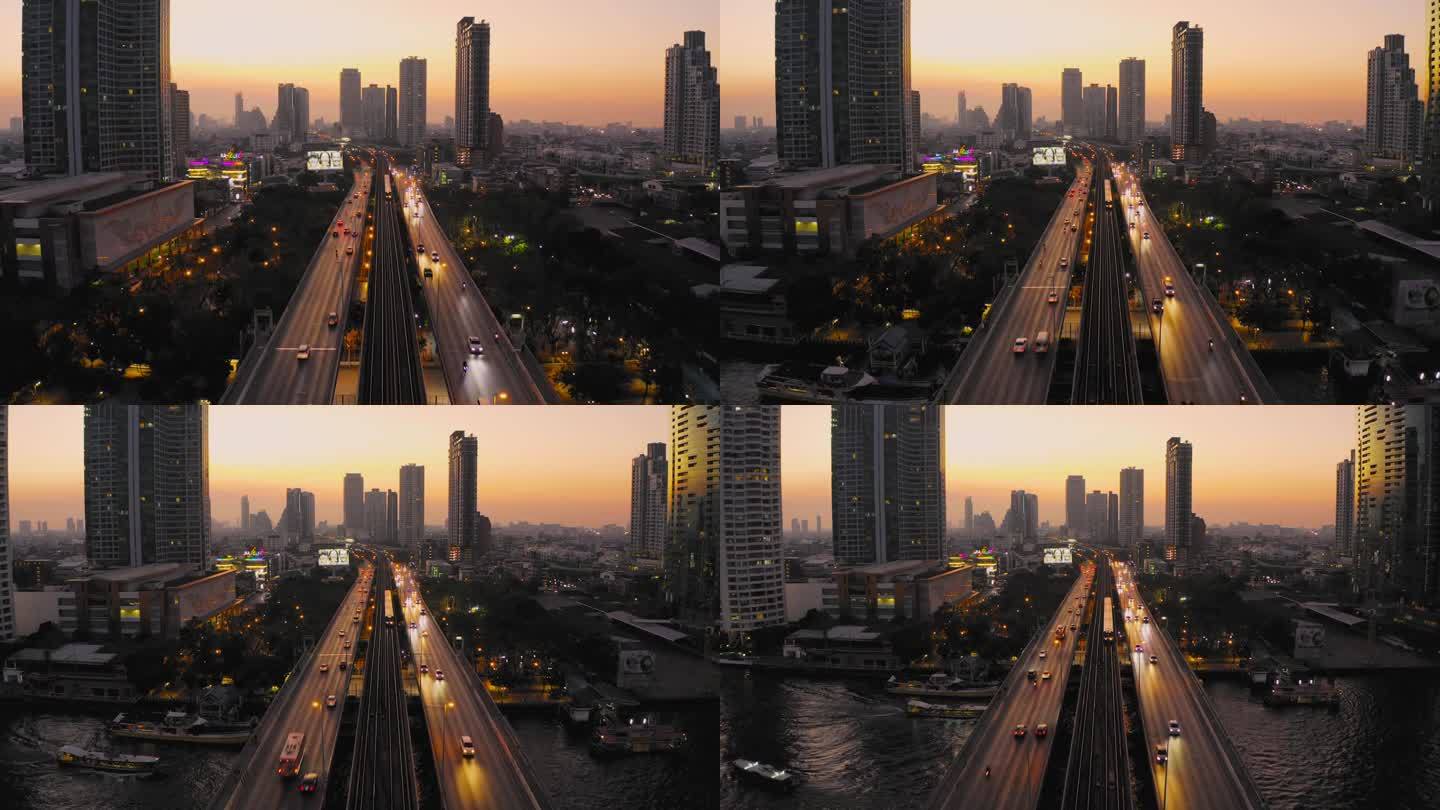 空中无人机拍摄的曼谷湄南河上高速公路和地铁轻轨上的交通信号灯日出场景