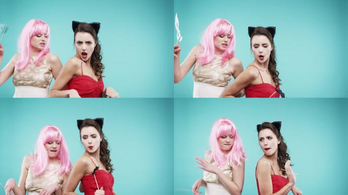 女友们穿着红裙子和粉色头发在慢镜头派对照相亭跳舞