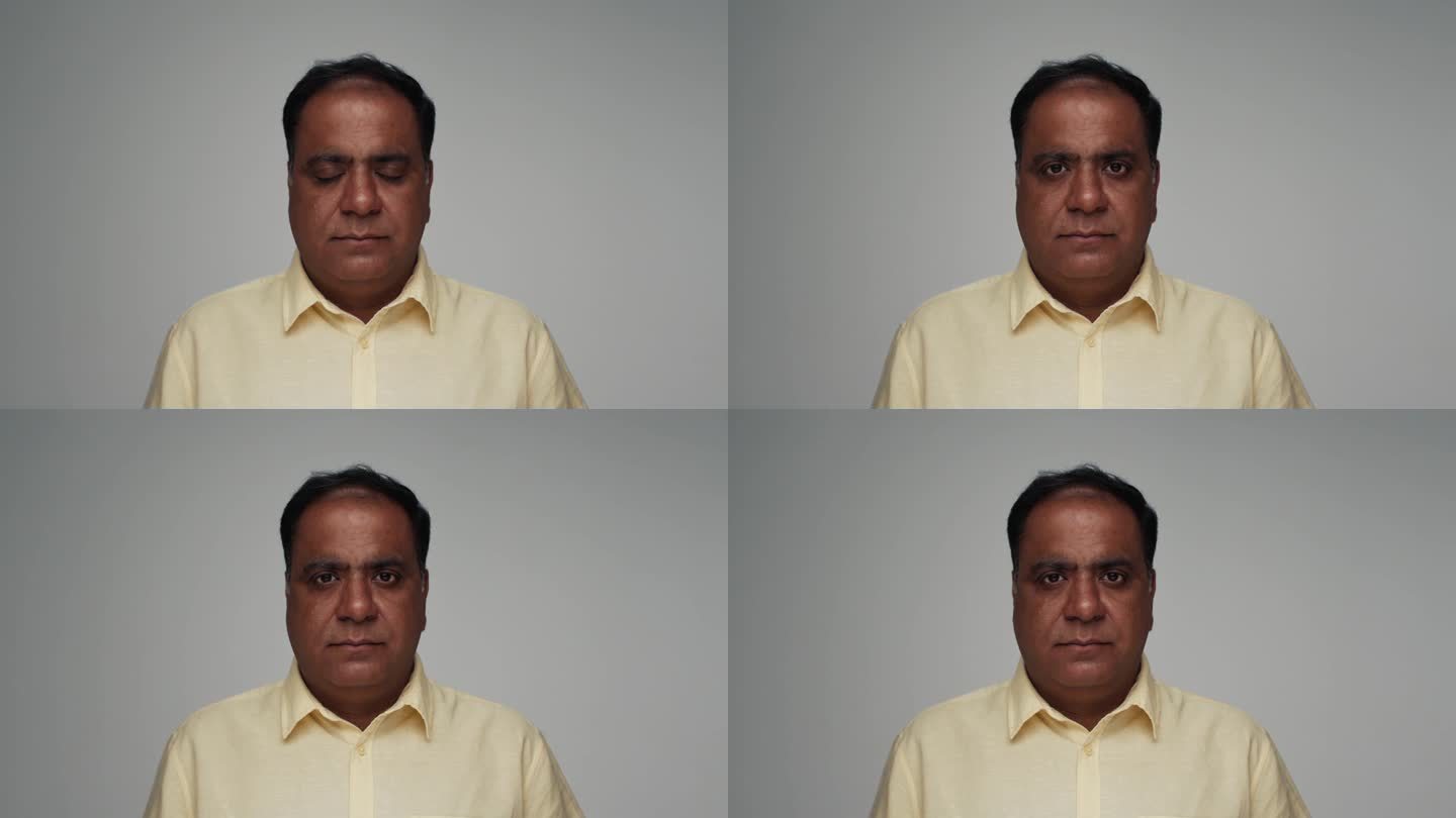 成年印度男子的肖像看着相机在彩色工作室拍摄。在灰色背景上，孤独的印度老男性特写。少数民族老年人以正常