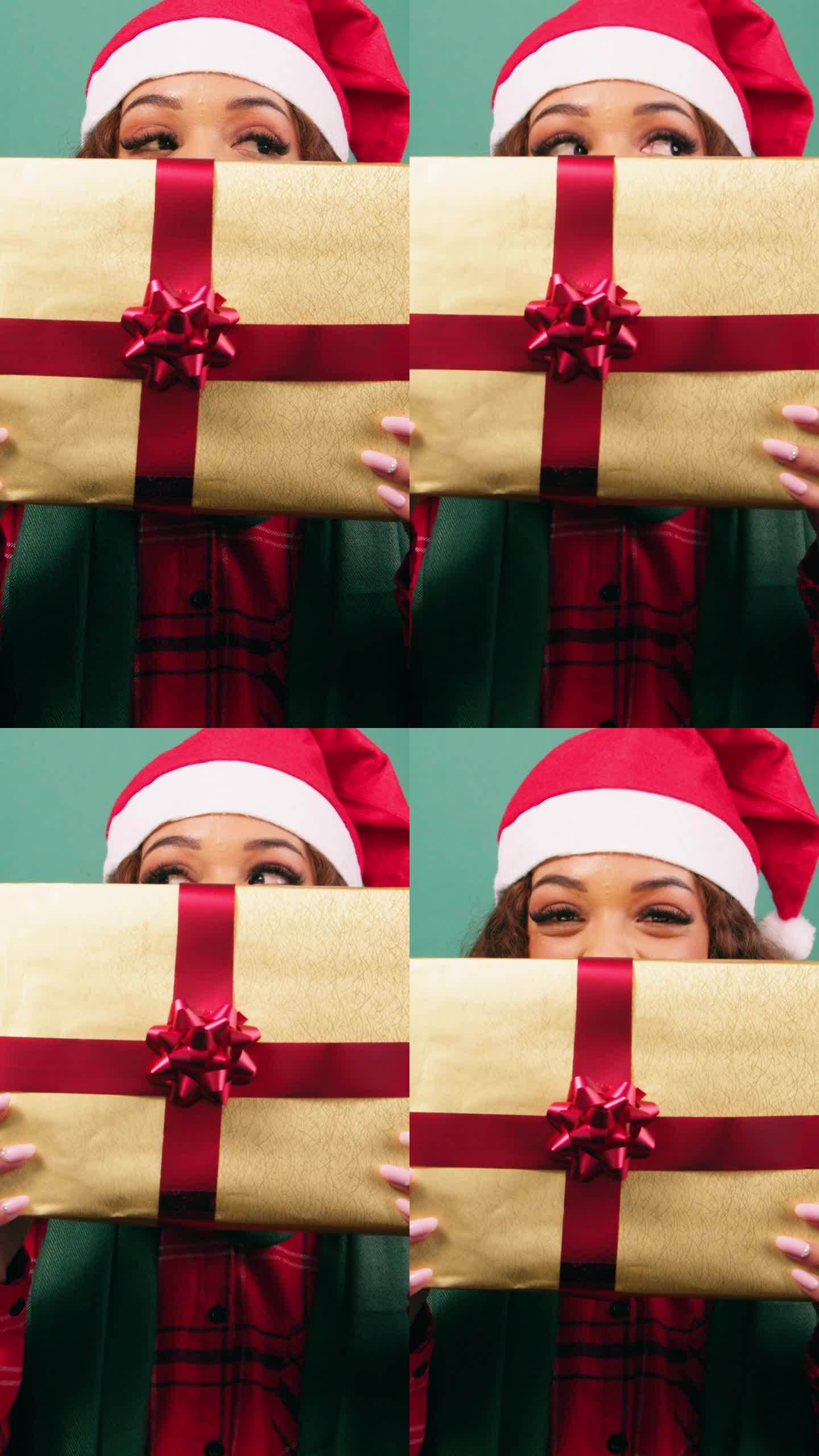 年轻女子躲在圣诞礼物后面，露出眼睛，录影棚
