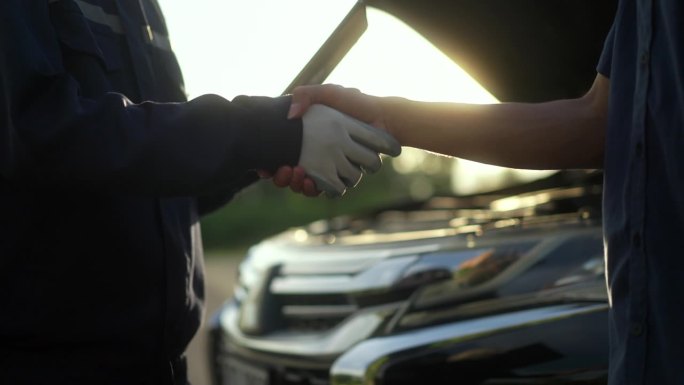 近距离的车主握手，以感谢熟练的修理工谁修理和精心照顾他们的车辆。修车外服。
