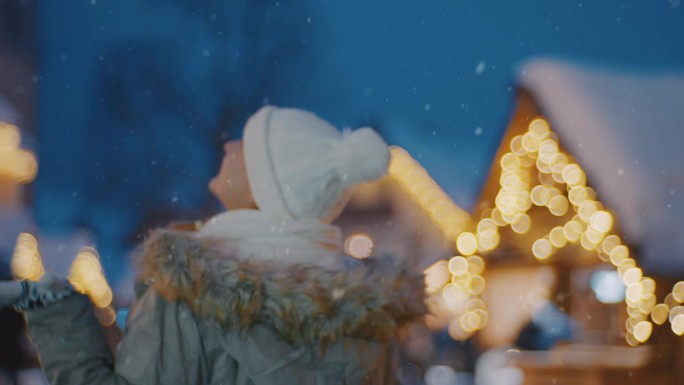 一名女子在雪中走过圣诞市场