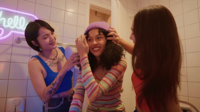 时尚女性在餐厅洗手间戴着针织帽欣赏朋友