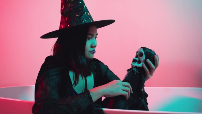 年轻女子在万圣节打扮成女巫。一个年轻女子在万圣节打扮成女巫。