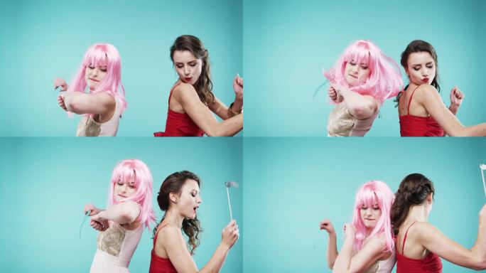 女友们穿着红裙子和粉色头发在慢镜头派对照相亭跳舞