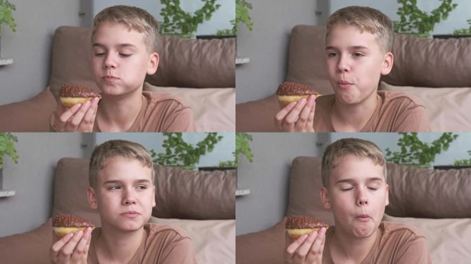 一个青少年愉快地咬了一口巧克力甜甜圈。不健康的甜食。