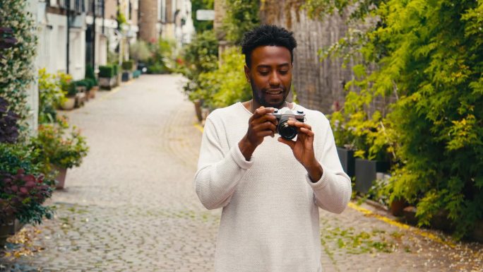 城市里的年轻人用数码相机拍照并发布到社交媒体上