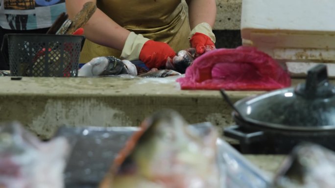 海鲜市场的鱼贩正在剥生鱼的内脏