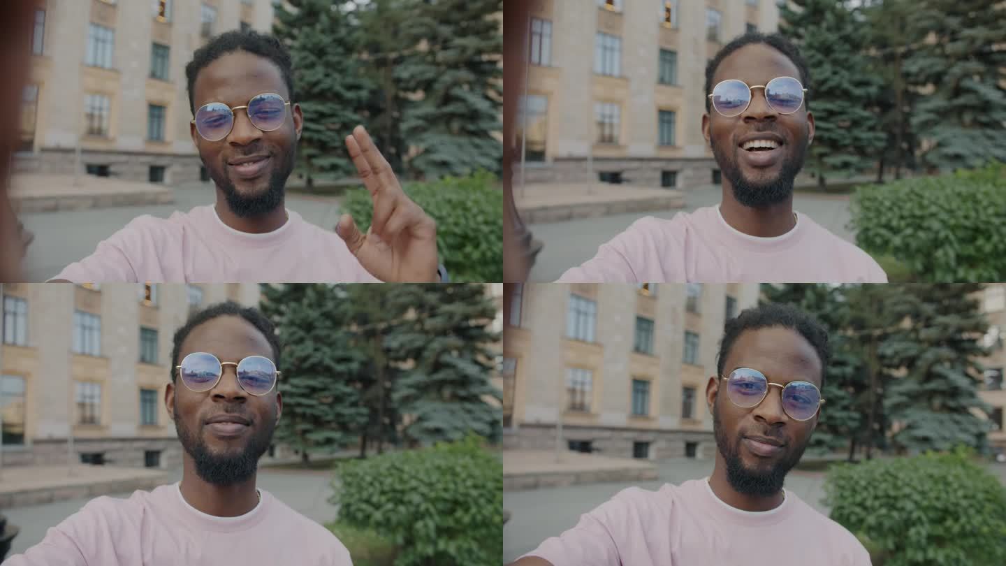 一个快乐的非洲裔美国人在城市户外用v手势和大拇指对着相机自拍