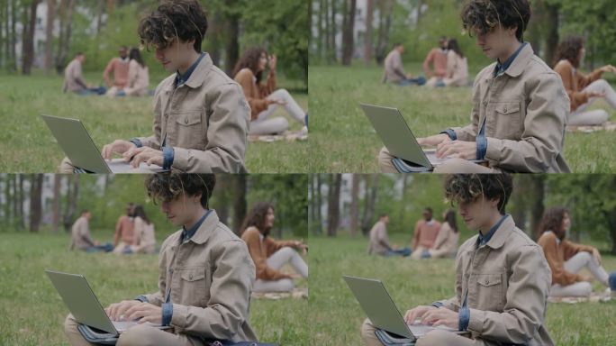 聪明的年轻人在公园学习，用笔记本电脑打字，专注于在线教育