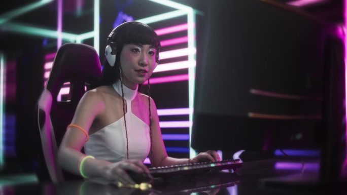 穿着白衣的时尚亚洲主播或游戏玩家在未来网络技术室的电脑上与互联网粉丝聊天。用于社交媒体、流媒体和游戏