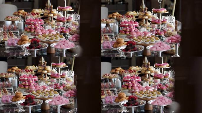 一张漂亮而甜蜜的桌子;马卡龙，小零食，三明治，粉色汉堡，糖果，饼干，纸杯蛋糕。一个装饰的新娘准备室桌