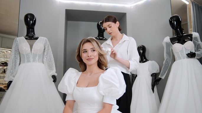 婚纱店老板在婚礼工作室帮忙挑选婚纱和试穿婚纱