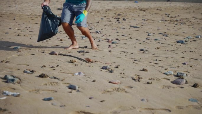 男性环保主义者在沙滩上清理垃圾