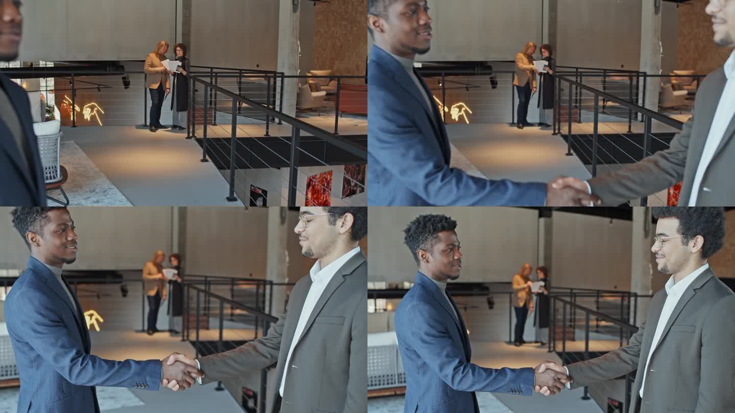 年轻的黑人商人在大厅与合作伙伴握手