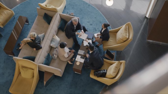 俯视图自信的企业家在宽敞的酒店大厅讨论业务