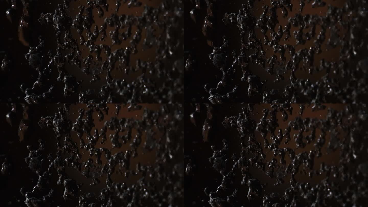 水珠融化的特写，在黑暗的背景下顺着玻璃流下。窗户上结霜的雨点。