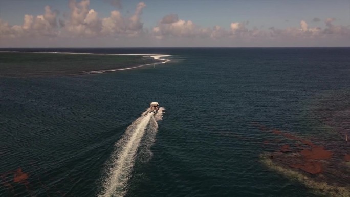 一艘快艇驶出大海，穿过大溪地提虎浦两个礁石之间的通道
