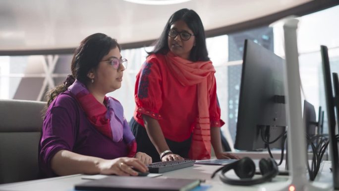 两个美丽的印度女人在一家银行的商业软件开发部门工作。专家讨论财政年度结果、报告和营销活动结果