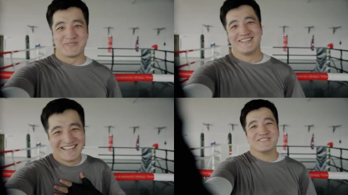 快乐的亚洲运动员在健身房进行在线视频通话，看着镜头，穿着制服
