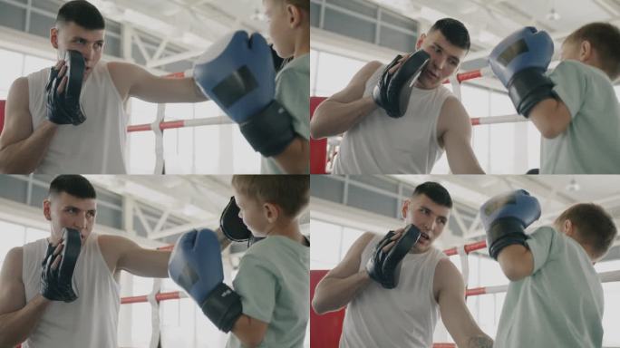 慢动作的拳击教练教孩子的防御动作和孩子说话戴手套在环