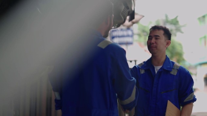 两位亚洲汽车机修队技师技师或工人在车库汽车机修队服务中心握手庆祝成功共同完成交易承诺。