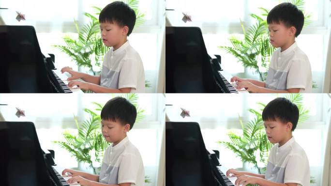 可爱快乐微笑的亚洲小男孩在家里的客厅里弹钢琴