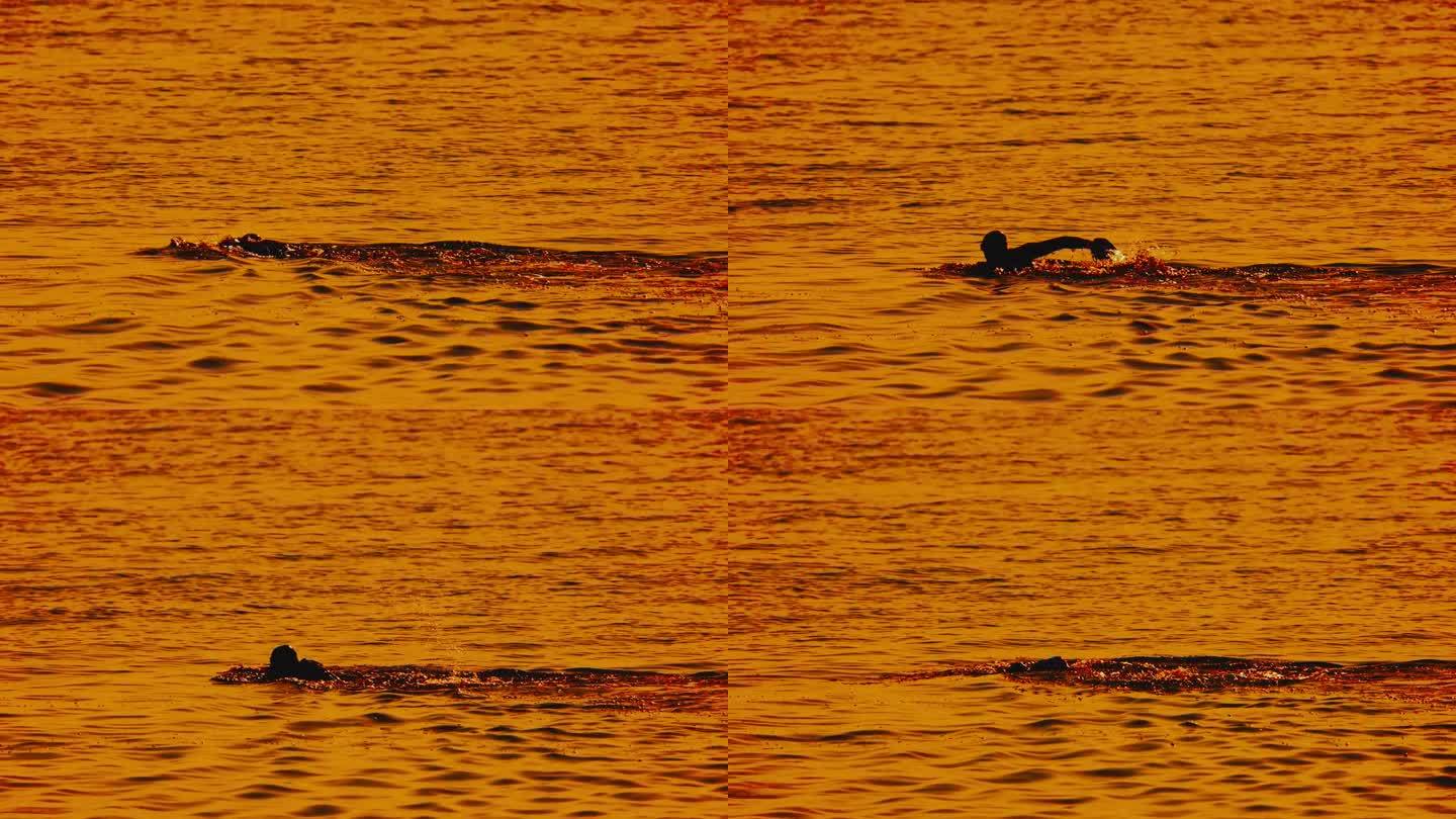 日落时在海里游泳的运动男子