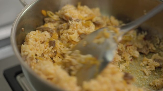 在锅里加入米饭，用平底锅煎猪肉和泡菜，翻炒。