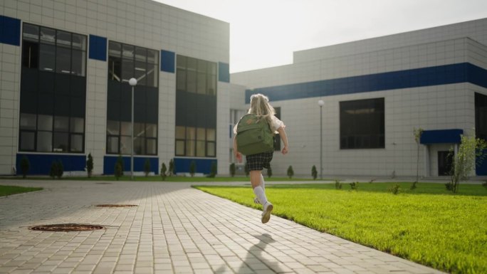 快乐的小女孩背着书包跑去上课，女学生的背影