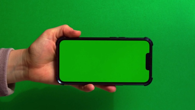 手持绿屏绿背景的手机。色度键模拟。你的产品的手机模型。技术手机触摸信息移动应用程序