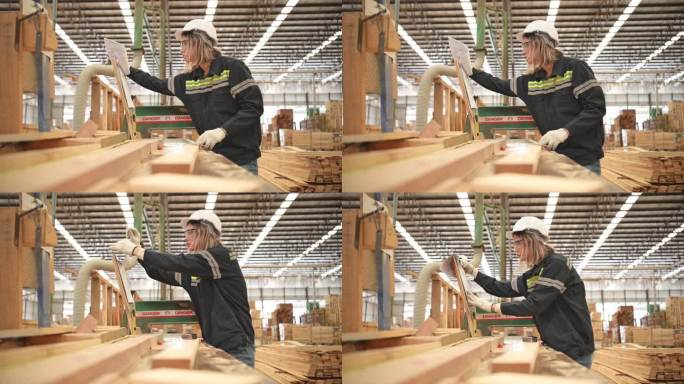 在一家木工工厂工作的女木匠，她戴着安全帽和眼镜。对照设计文件检查板材的整齐程度。