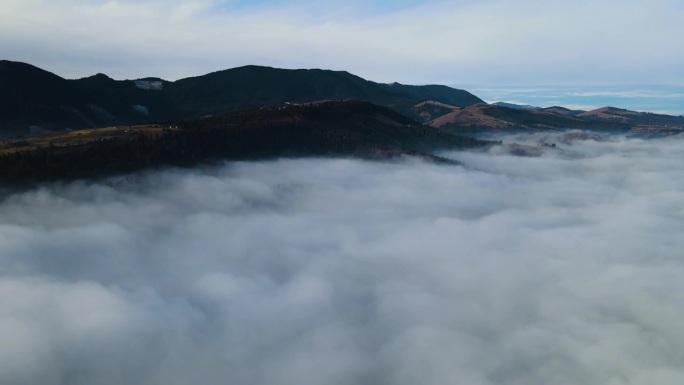 飞过山顶的云层。山峰高耸，清晨日出，自然景观优美