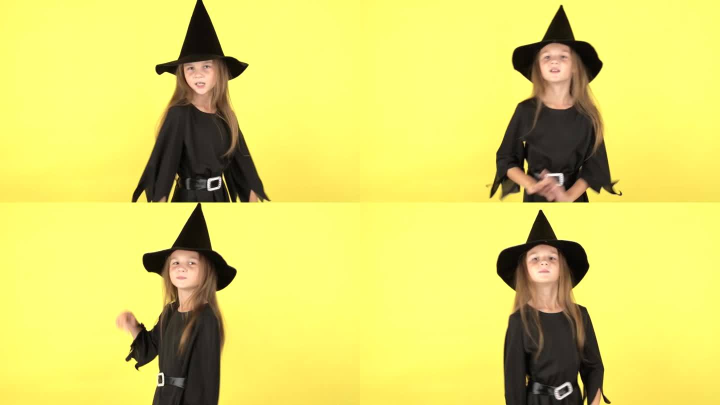 一个穿着万圣节女巫服装的小女孩在黄色的工作室背景上跳舞并表现出情感